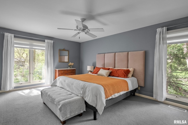 bedroom with carpet floors, multiple windows, ceiling fan, and visible vents