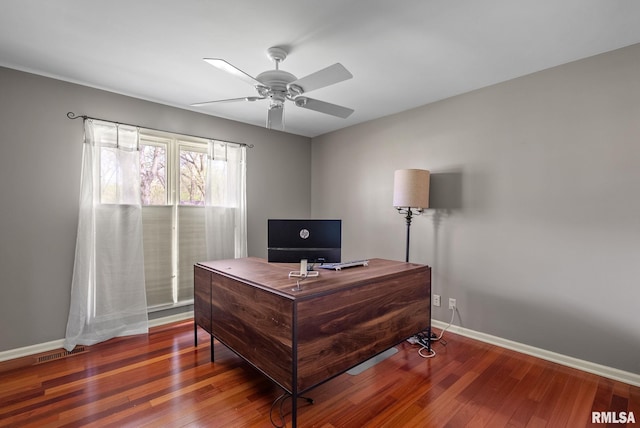 office featuring baseboards, a ceiling fan, wood finished floors, and visible vents