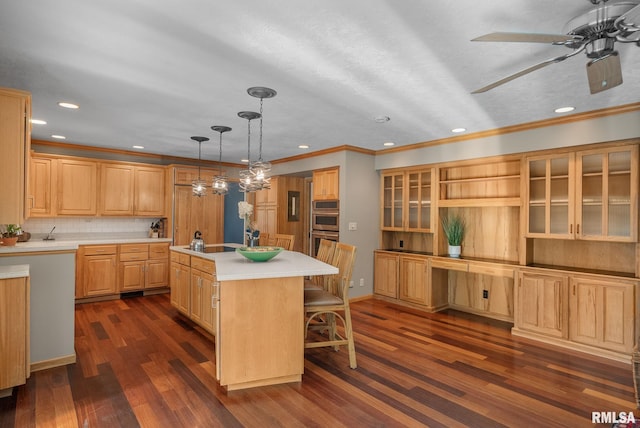 kitchen with crown molding, recessed lighting, dark wood finished floors, and an island with sink