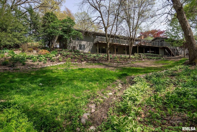 view of yard featuring stairs and a wooden deck