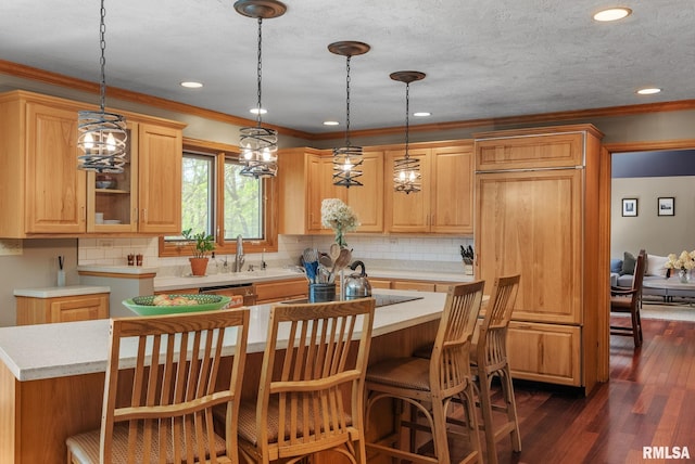 kitchen featuring light countertops, crown molding, dark wood finished floors, and decorative light fixtures