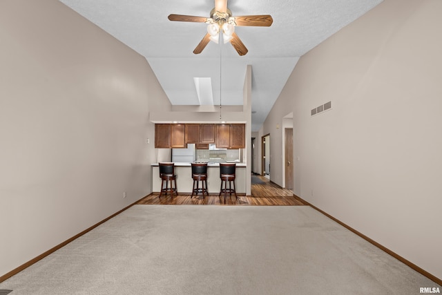 kitchen featuring carpet floors, ceiling fan, baseboards, and visible vents