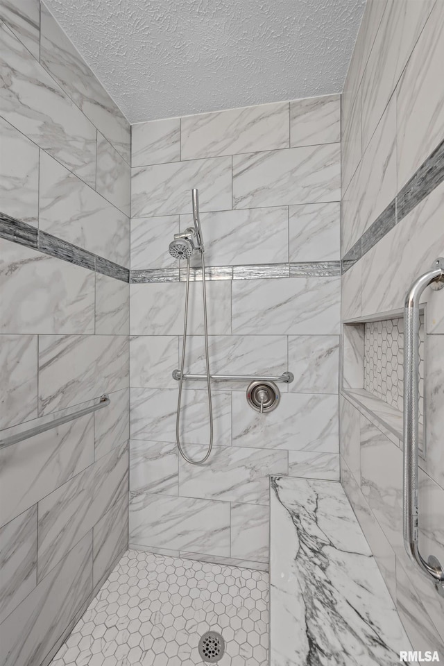 bathroom featuring a textured ceiling and tiled shower