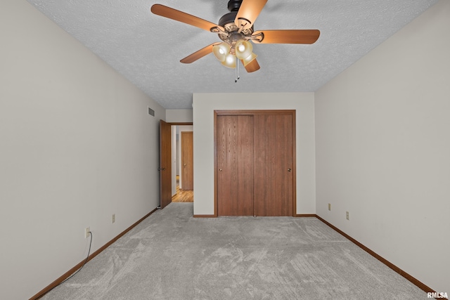 unfurnished bedroom featuring baseboards, carpet, a closet, and a textured ceiling