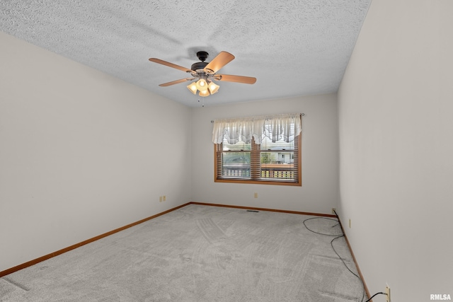 empty room featuring baseboards, ceiling fan, light carpet, and a textured ceiling