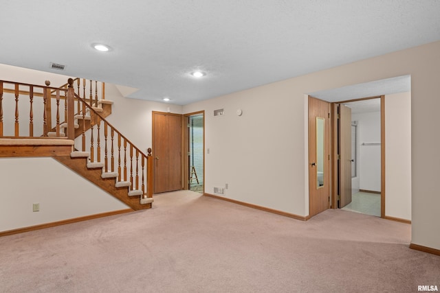 unfurnished living room featuring carpet floors, baseboards, stairs, and visible vents
