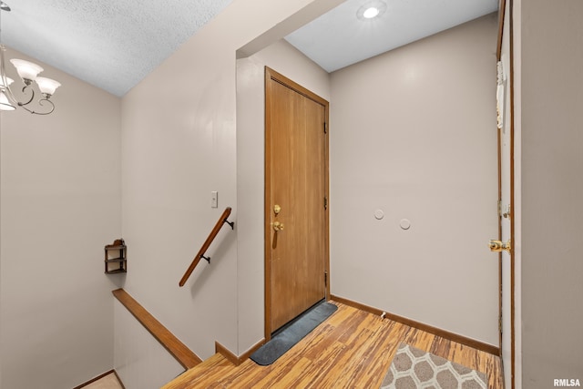 entrance foyer featuring baseboards, recessed lighting, light wood finished floors, and a notable chandelier