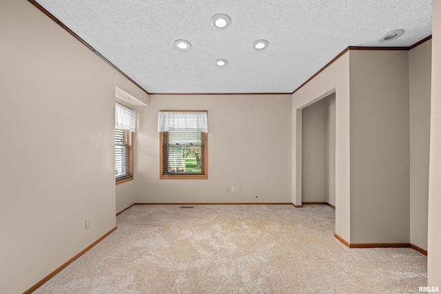 unfurnished room featuring ornamental molding, carpet, and a textured ceiling