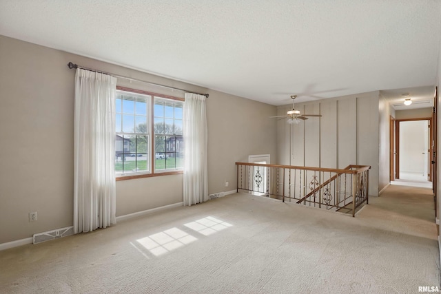 carpeted spare room featuring baseboards and visible vents