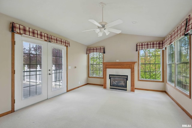 unfurnished living room featuring carpet floors, lofted ceiling, baseboards, french doors, and a fireplace with flush hearth
