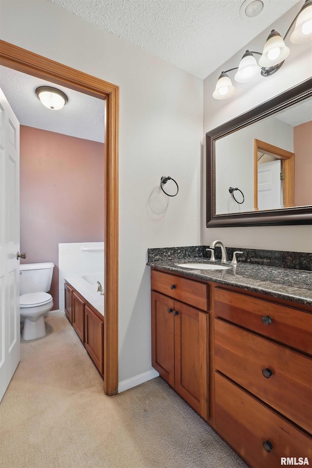 bathroom with a bath, a textured ceiling, vanity, toilet, and carpet flooring