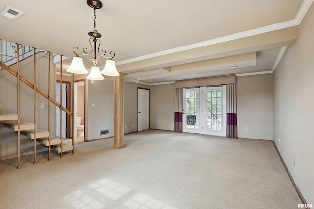 spare room featuring carpet flooring, crown molding, visible vents, and stairway