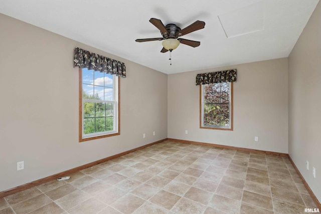 empty room with light tile patterned floors, baseboards, and ceiling fan