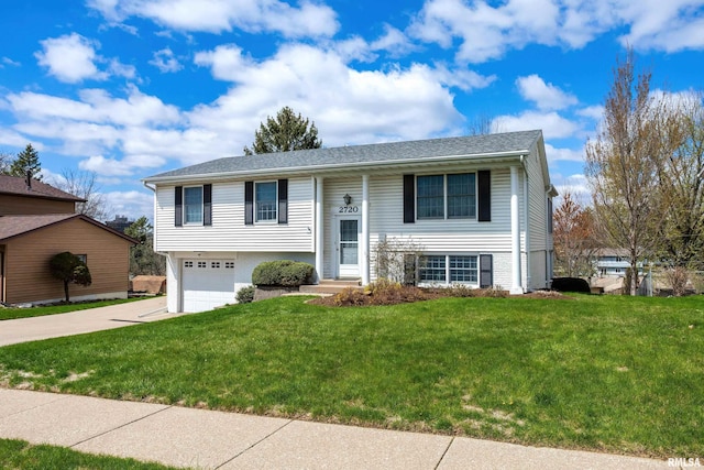 bi-level home with an attached garage, a front lawn, and concrete driveway