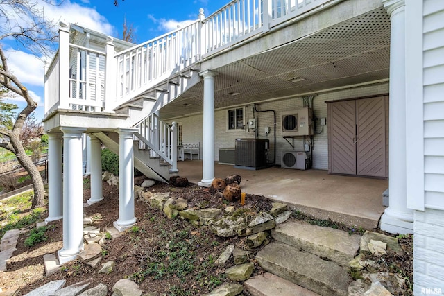 view of patio with stairs, ac unit, central AC, and a deck