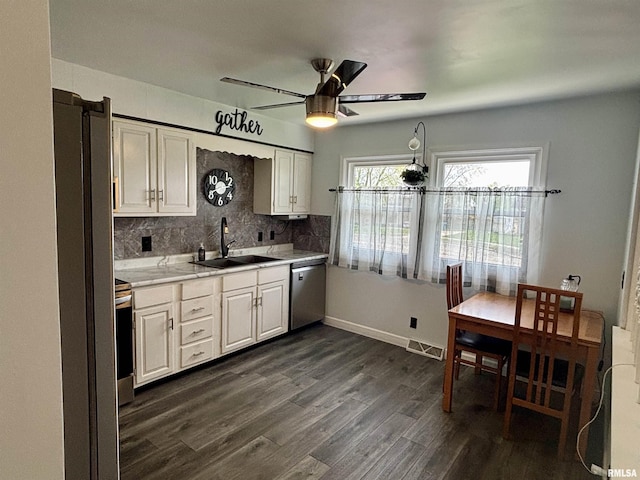 kitchen featuring dark wood-style flooring, ceiling fan, a sink, stainless steel dishwasher, and visible vents