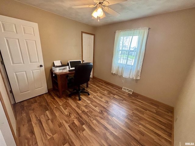 office space with a ceiling fan, baseboards, visible vents, and wood finished floors