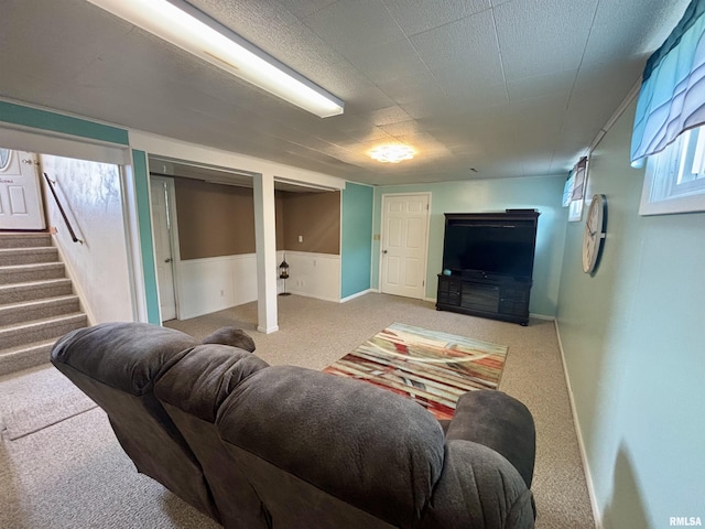 living area with stairs and carpet
