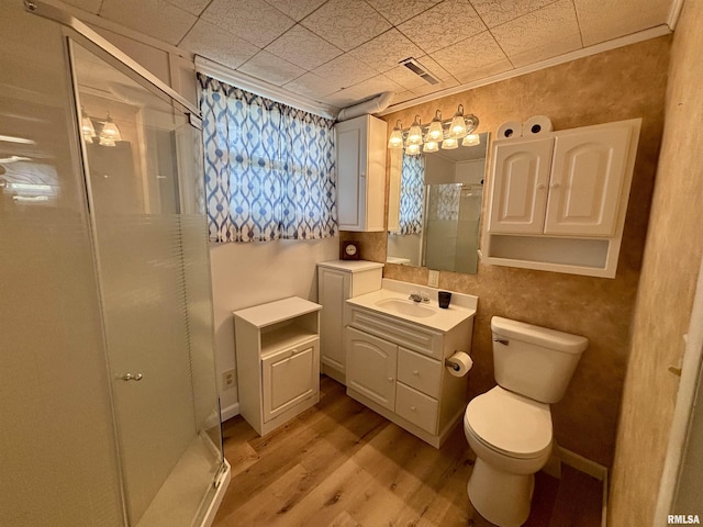 bathroom featuring vanity, visible vents, wood finished floors, toilet, and a shower stall