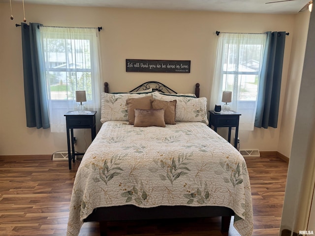 bedroom with baseboards, dark wood-style flooring, and visible vents