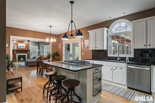 kitchen featuring a center island, a sink, appliances with stainless steel finishes, and backsplash