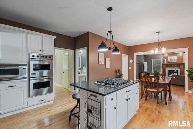 kitchen featuring light wood-type flooring, white cabinets, and stainless steel appliances