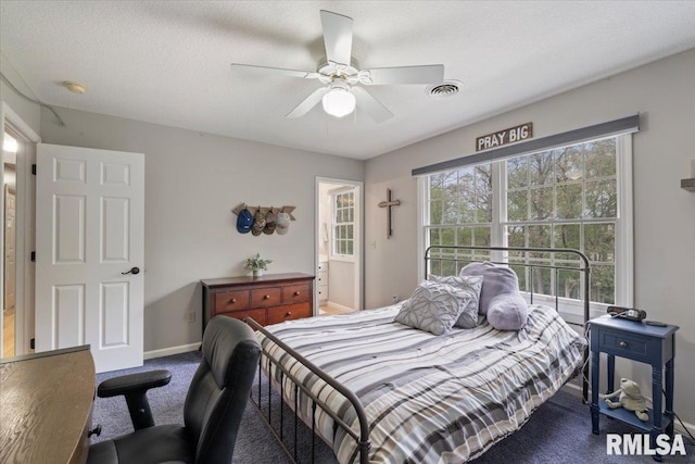 carpeted bedroom featuring baseboards, visible vents, and ceiling fan