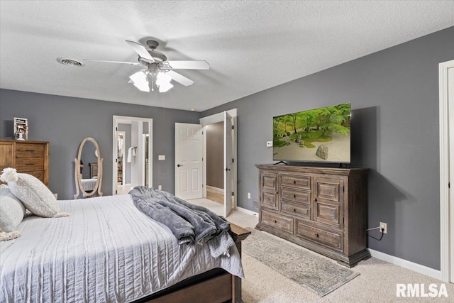 bedroom with baseboards, a textured ceiling, ceiling fan, and light carpet