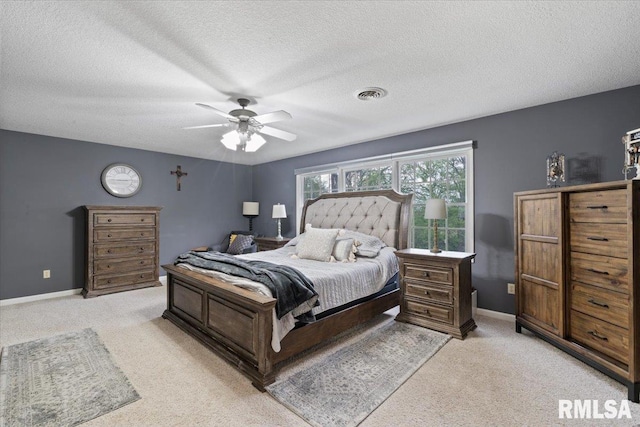 bedroom with a textured ceiling, visible vents, and light carpet