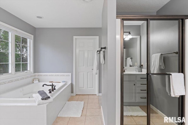 bathroom with a jetted tub, baseboards, tile patterned floors, and vanity