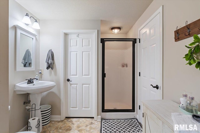 bathroom featuring baseboards, tile patterned floors, and a stall shower