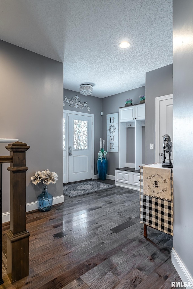 foyer entrance with baseboards, recessed lighting, a textured ceiling, and dark wood-style floors