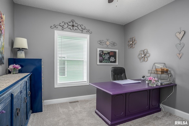 office featuring baseboards, ceiling fan, light carpet, and visible vents
