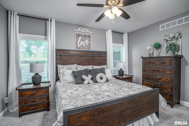 bedroom featuring carpet floors, a textured ceiling, baseboards, and visible vents