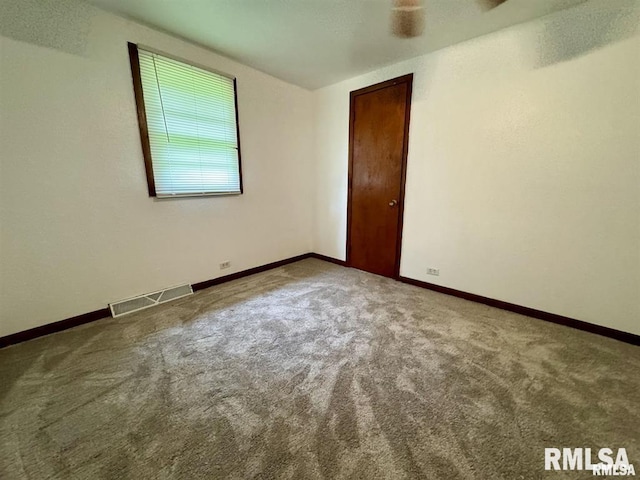 carpeted spare room featuring baseboards