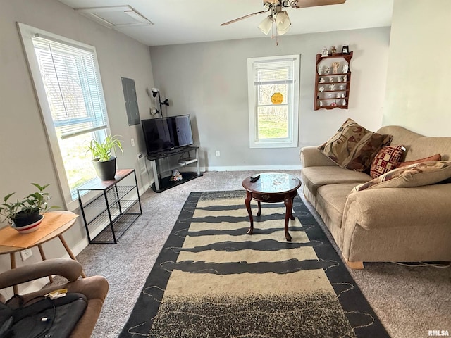 carpeted living area featuring baseboards, ceiling fan, and a healthy amount of sunlight