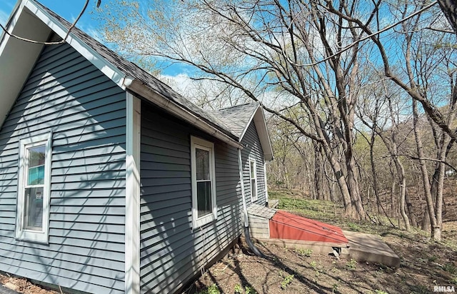 view of side of property with a shingled roof