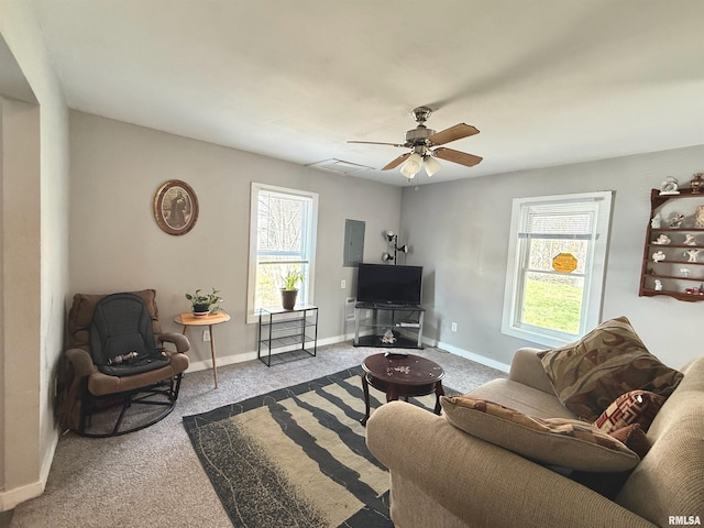 carpeted living room featuring plenty of natural light, a ceiling fan, and baseboards