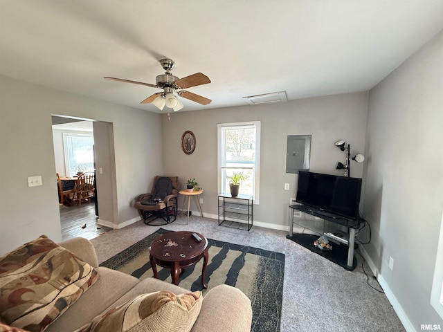 living area with a healthy amount of sunlight, carpet, electric panel, and a ceiling fan