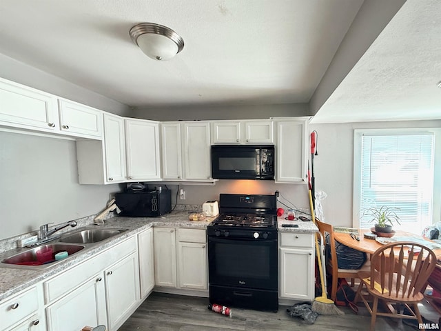 kitchen featuring a sink, black appliances, dark wood-style floors, and white cabinetry