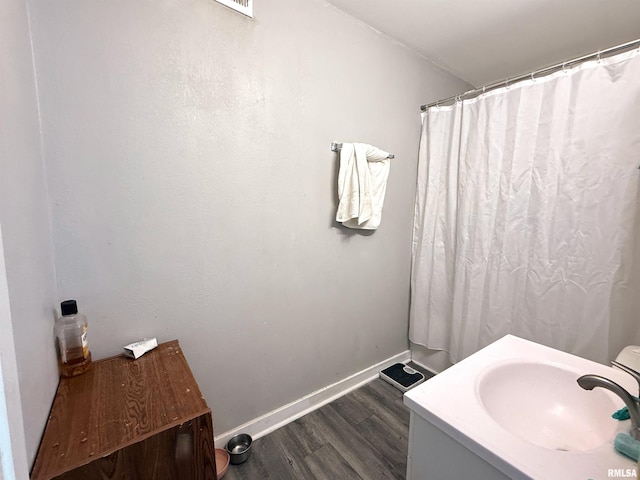 bathroom featuring baseboards, vanity, and wood finished floors
