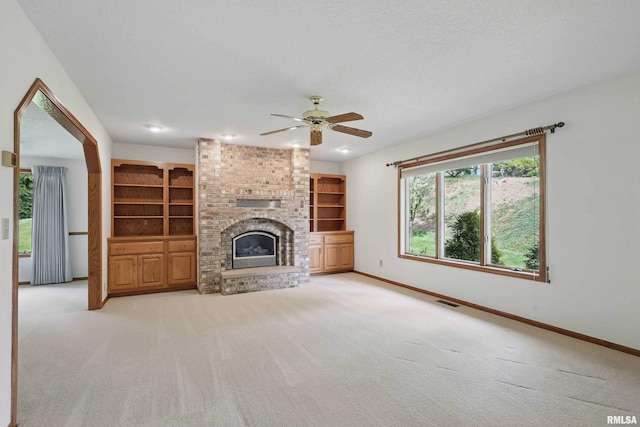 unfurnished living room featuring a ceiling fan, light colored carpet, visible vents, and baseboards
