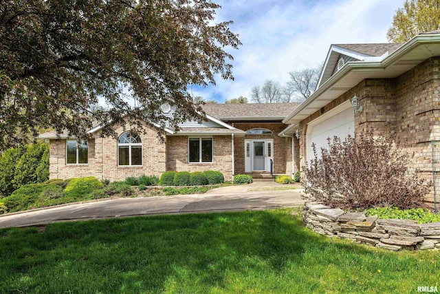 view of front of property with brick siding, a shingled roof, a front lawn, and a garage
