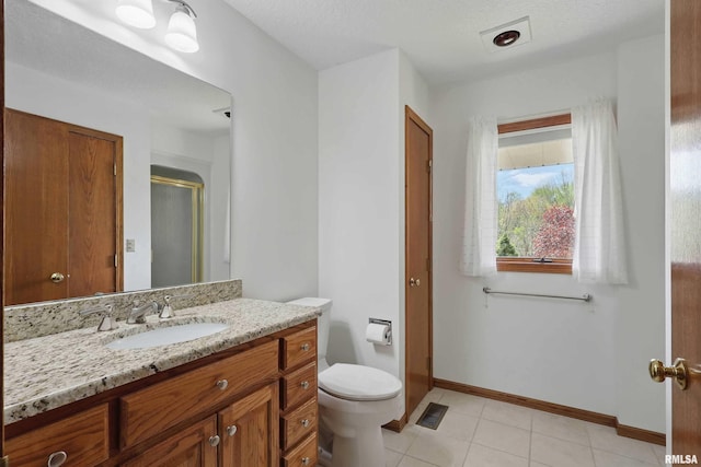 bathroom with vanity, toilet, baseboards, visible vents, and a stall shower