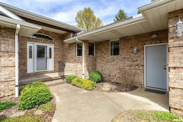 view of exterior entry featuring brick siding