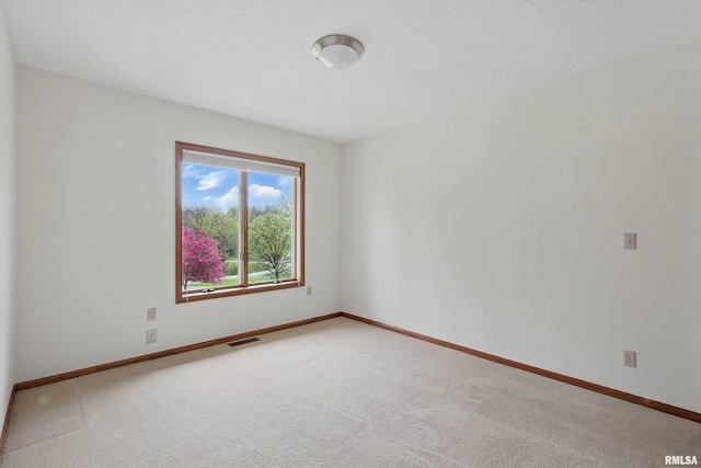 unfurnished room featuring baseboards, visible vents, and light carpet