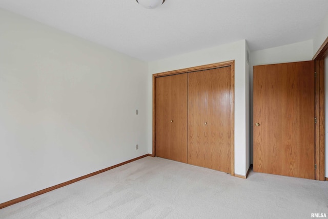 unfurnished bedroom featuring a closet, carpet flooring, and baseboards