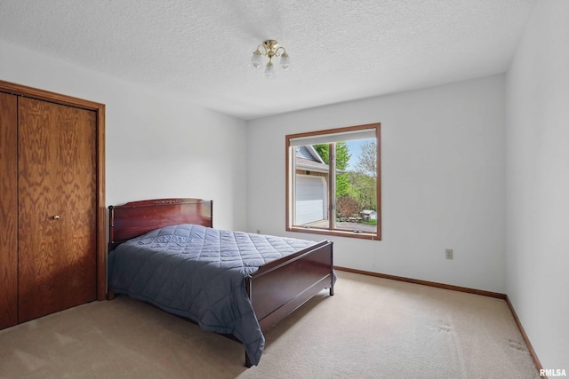bedroom featuring baseboards, carpet flooring, and a textured ceiling