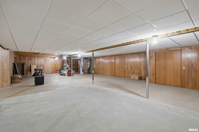 finished below grade area featuring wood walls and a paneled ceiling