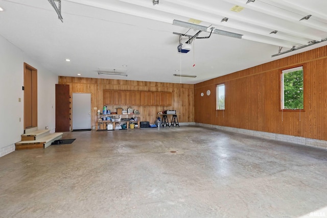 garage with a garage door opener and wooden walls
